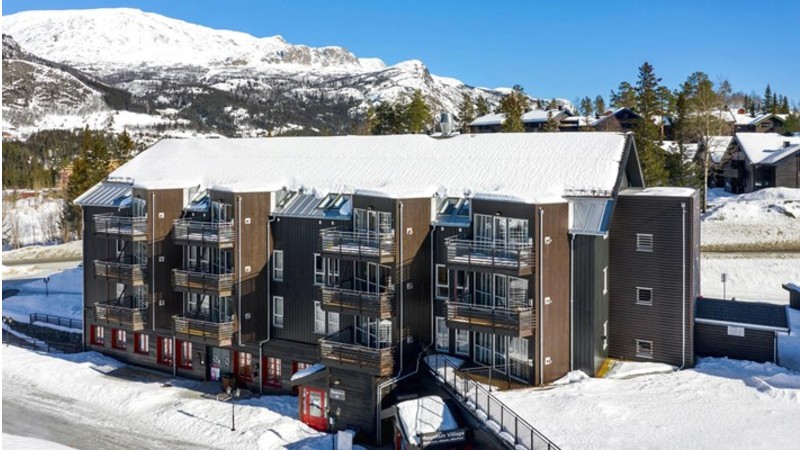 Staven del 1 sedd från backen. I bottenplan ligger Check-in 71 (röd dörr). Som bilgäst är det här ni hämta ut era nycklar. Här lämnar ni också in era nycklar efter er vistelse.